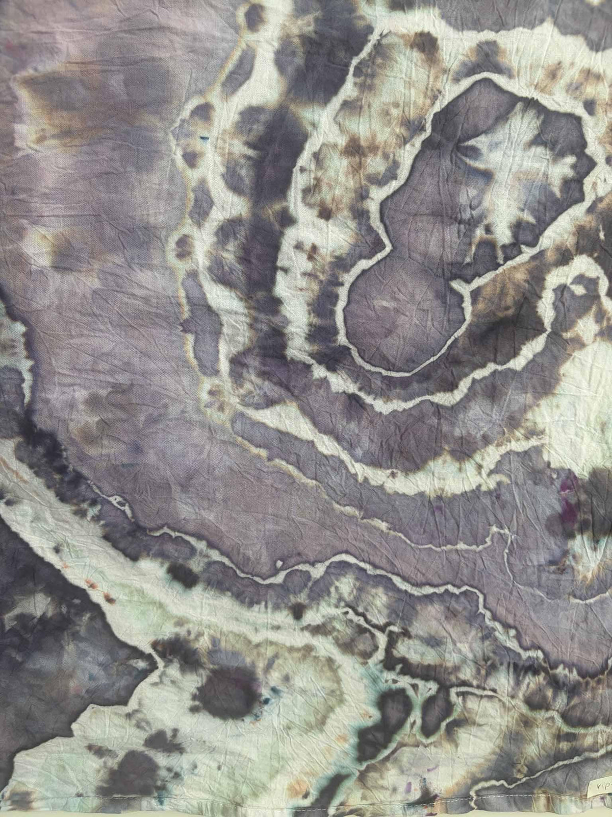 Close-up of ice dyed cotton with winding white lines and charcoal gray spots across soft lavender and stormy purple dye, with hints of seafoam green. __etsy:8672439207