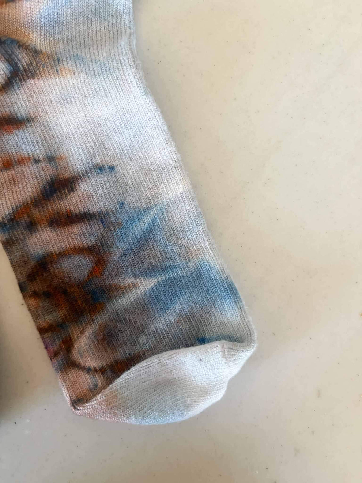 Close-up of sock toe showing rust and steel blue ice dye blend __etsy:8501098122
