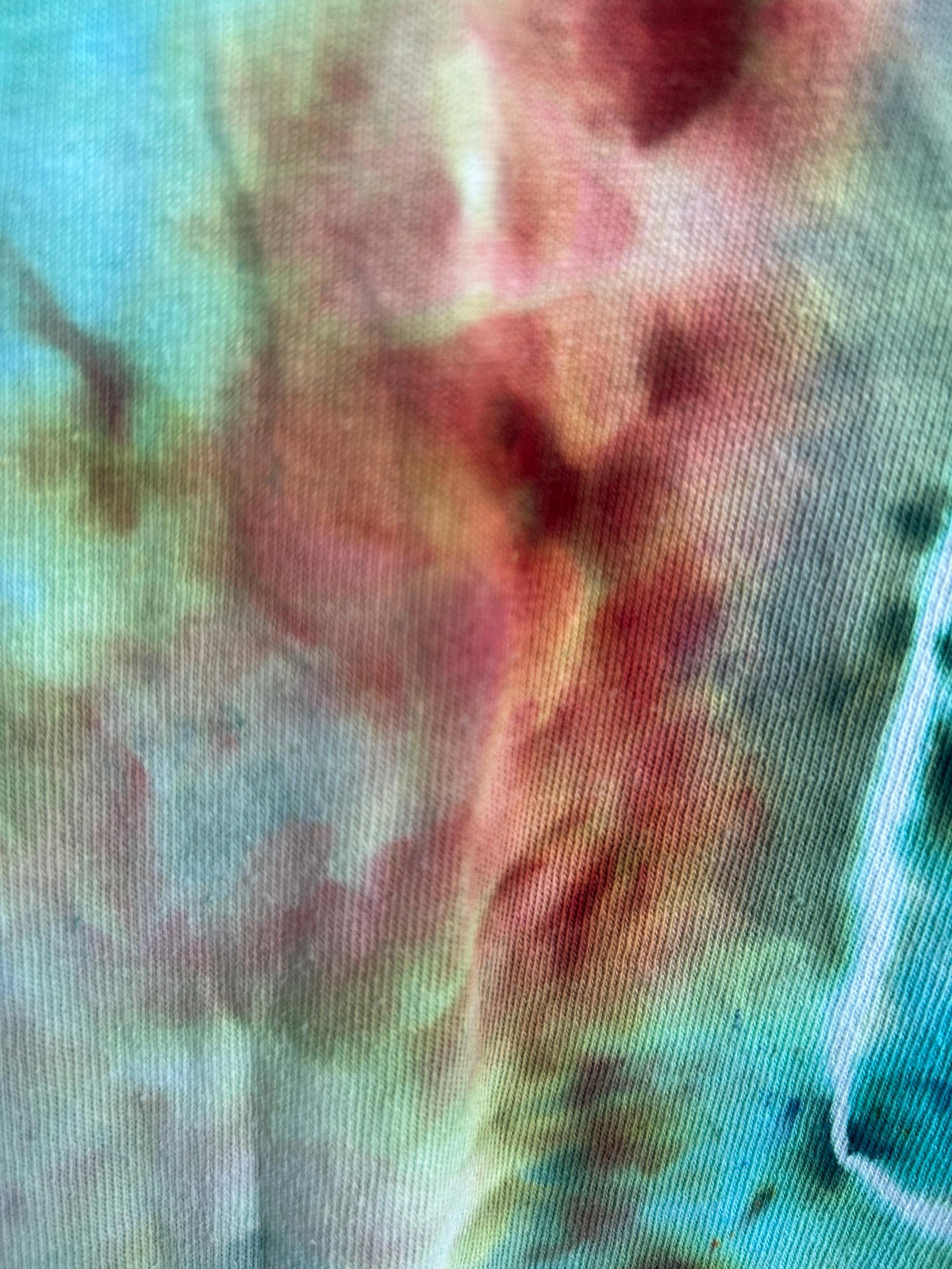 Hand dyed cotton ice dye dress in purple, teal, and mint colors showing geode-style pattern and fabric drape detail