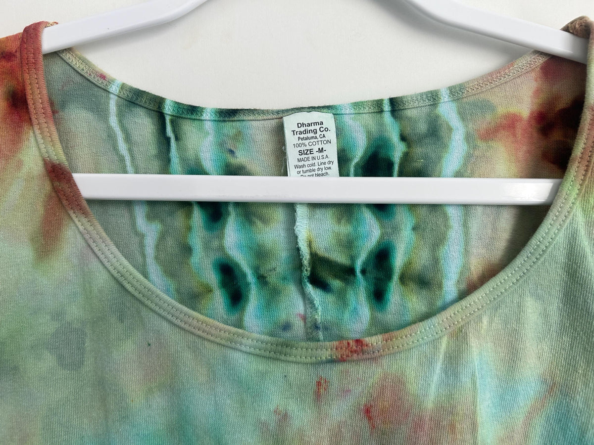 Front neckline of hand dyed ice dye dress showing purple, teal, and mint geode tie dye pattern on cotton fabric