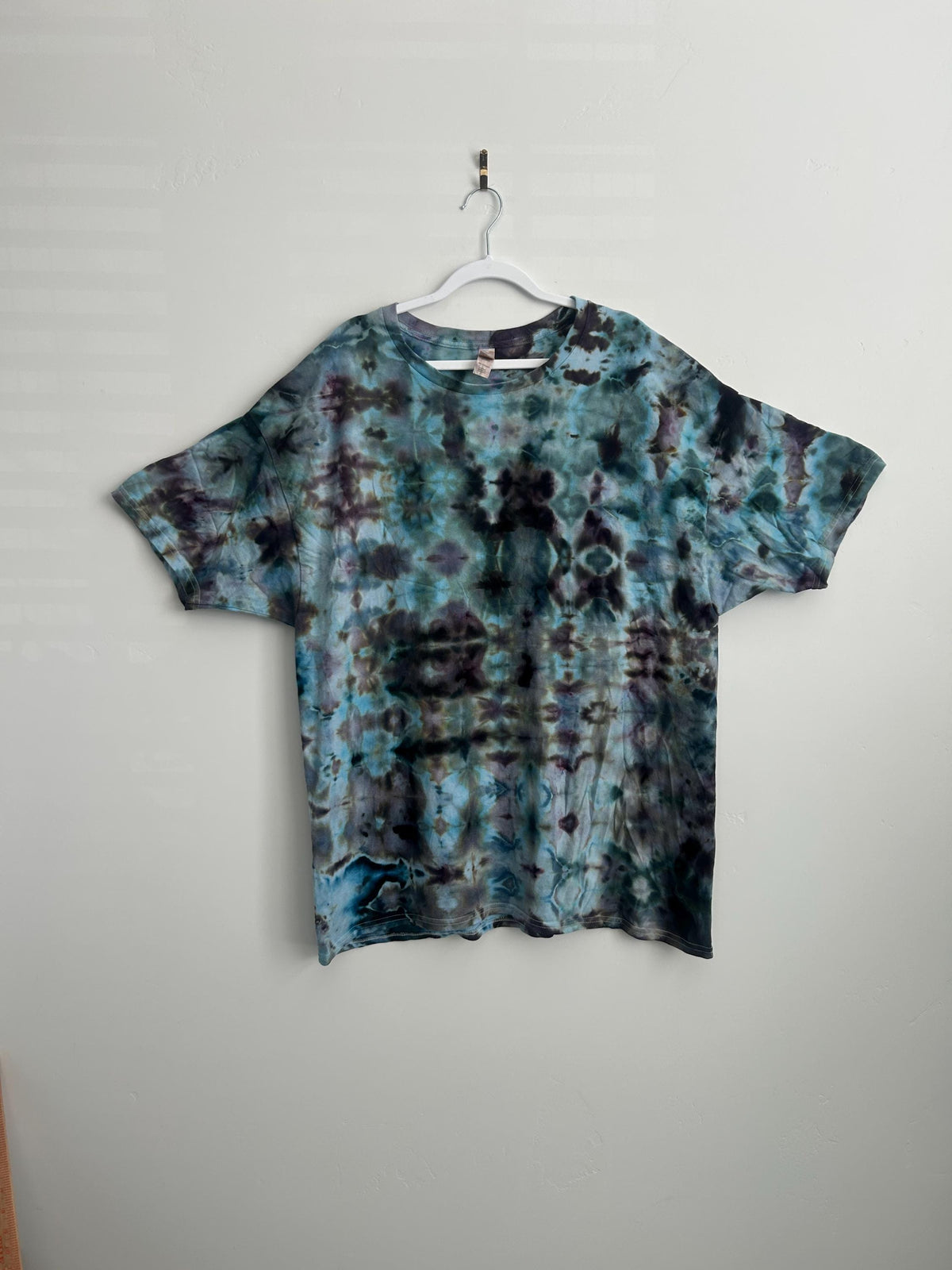 Blue purple black ice dye tie dye shirt front view on hanger showing ocean inspired pattern adult size 2XL cotton Hanes shirt