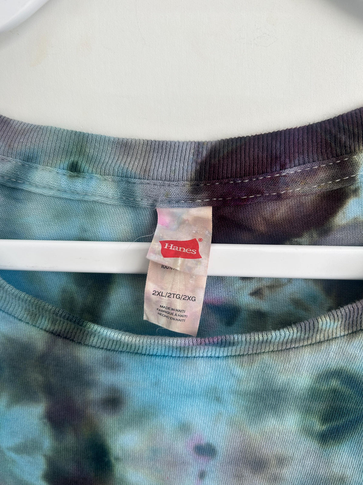 Hanes 2XL size tag close up on handmade ice dyed tie dye shirt showing brand and size information