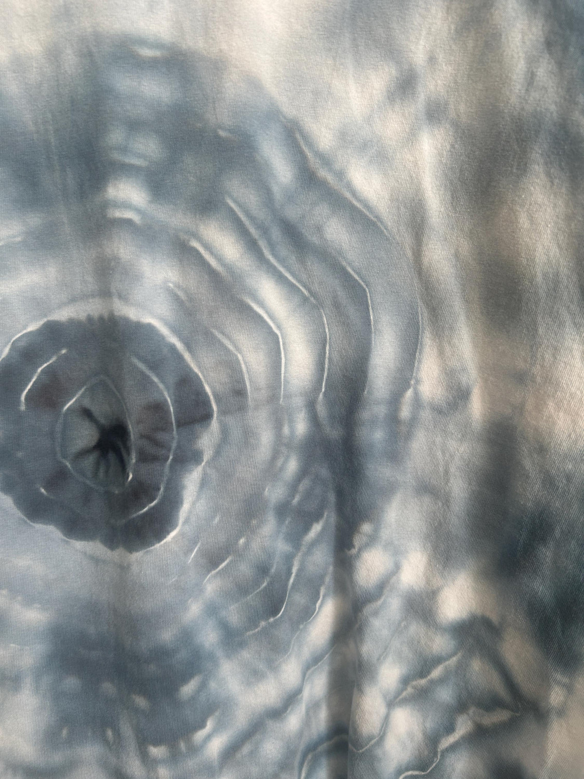 Close up detail of geode ice dye pattern on gray t-shirt showing concentric rings and dark center