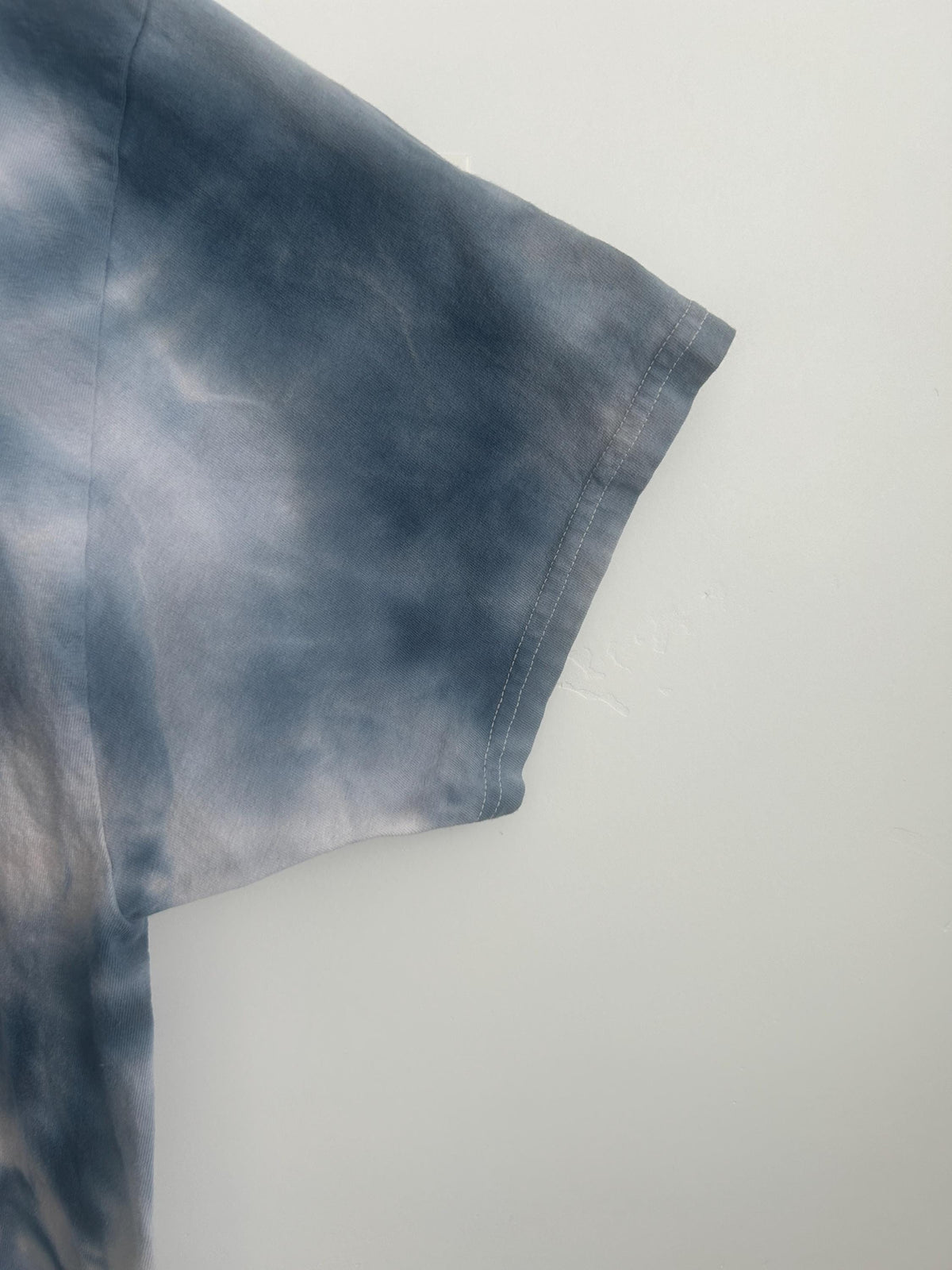 Sleeve detail of ice dye geode t-shirt in slate gray showing dye texture