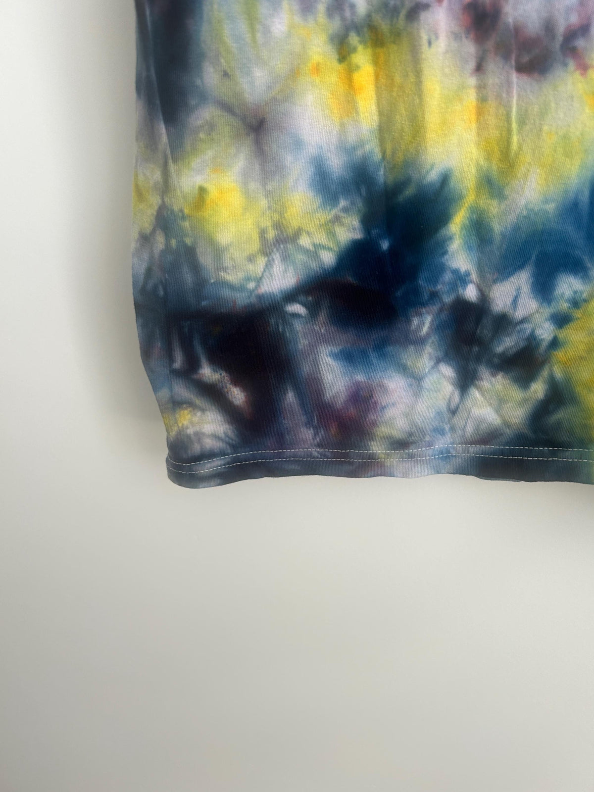 Hem detail showing deep navy, plum, and yellow ice dye blending along the bottom edge