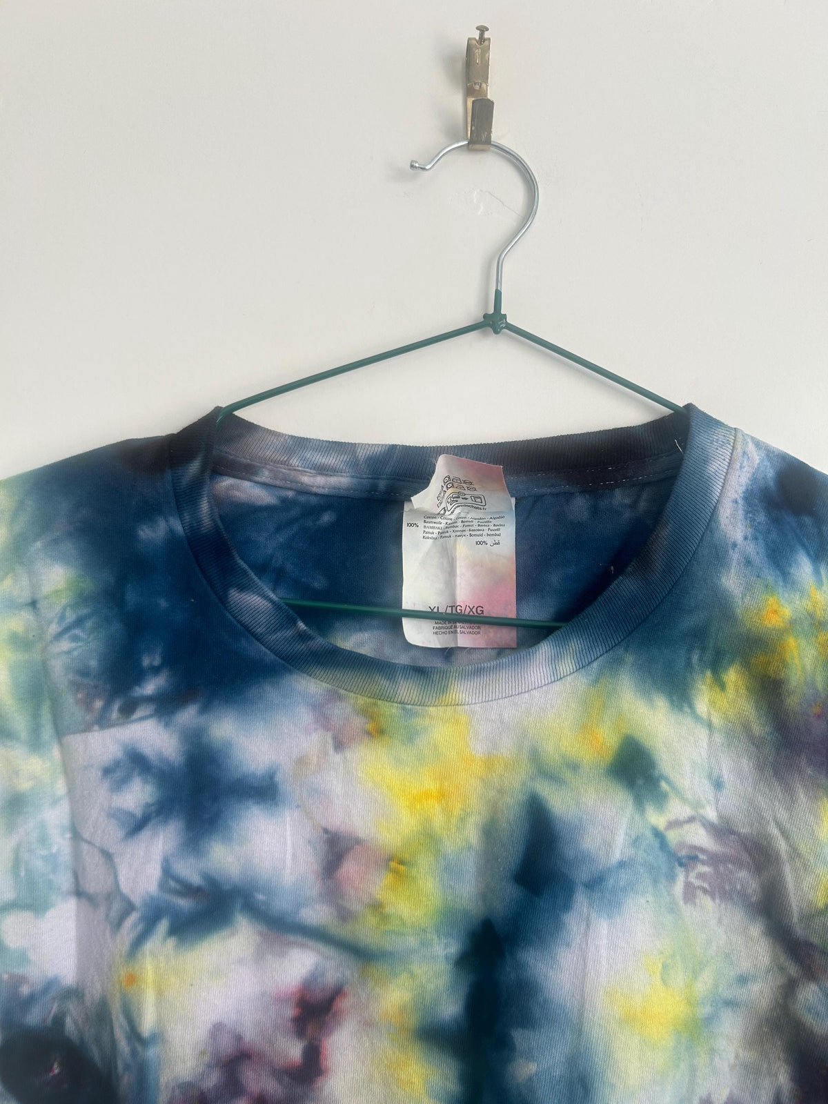 Neckline detail showing Fruit of the Loom XL tag with dark navy collar and ice dye pattern