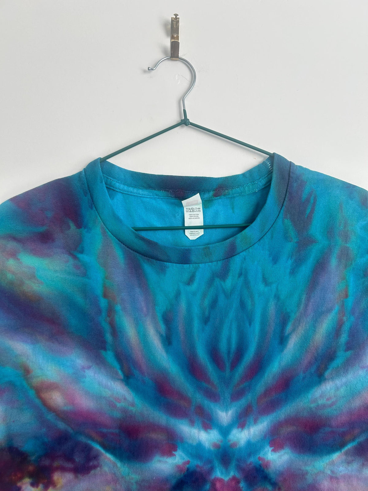 Close-up of the upper chest showing the teal mirrored ice dye detail near the neckline