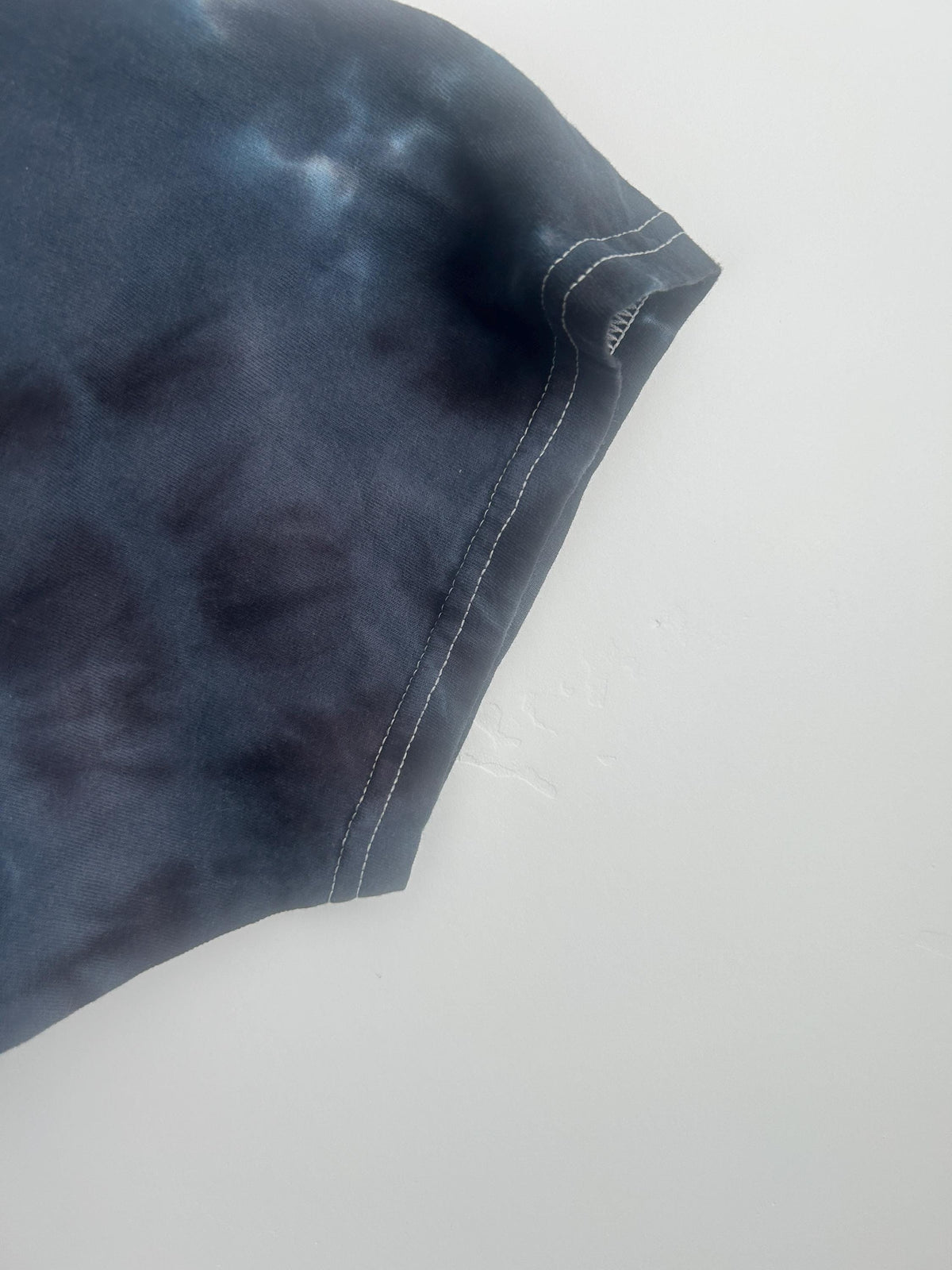 Sleeve detail of black and white bullseye tie dye t-shirt showing dye texture