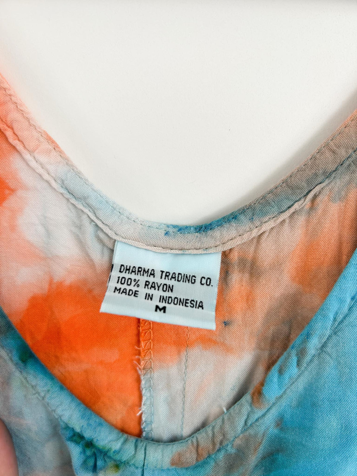 Close up of Dharma Trading Co label showing 100 percent rayon size medium on hand dyed sundress