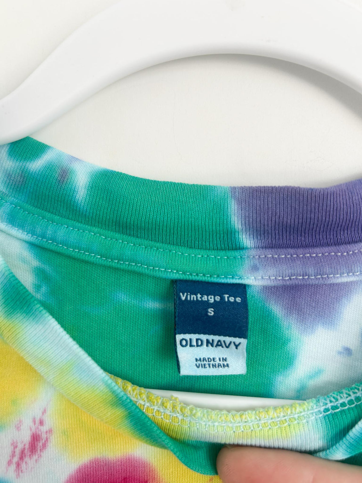Close up of Old Navy Vintage Tee size small label on hand dyed rainbow spiral crop top