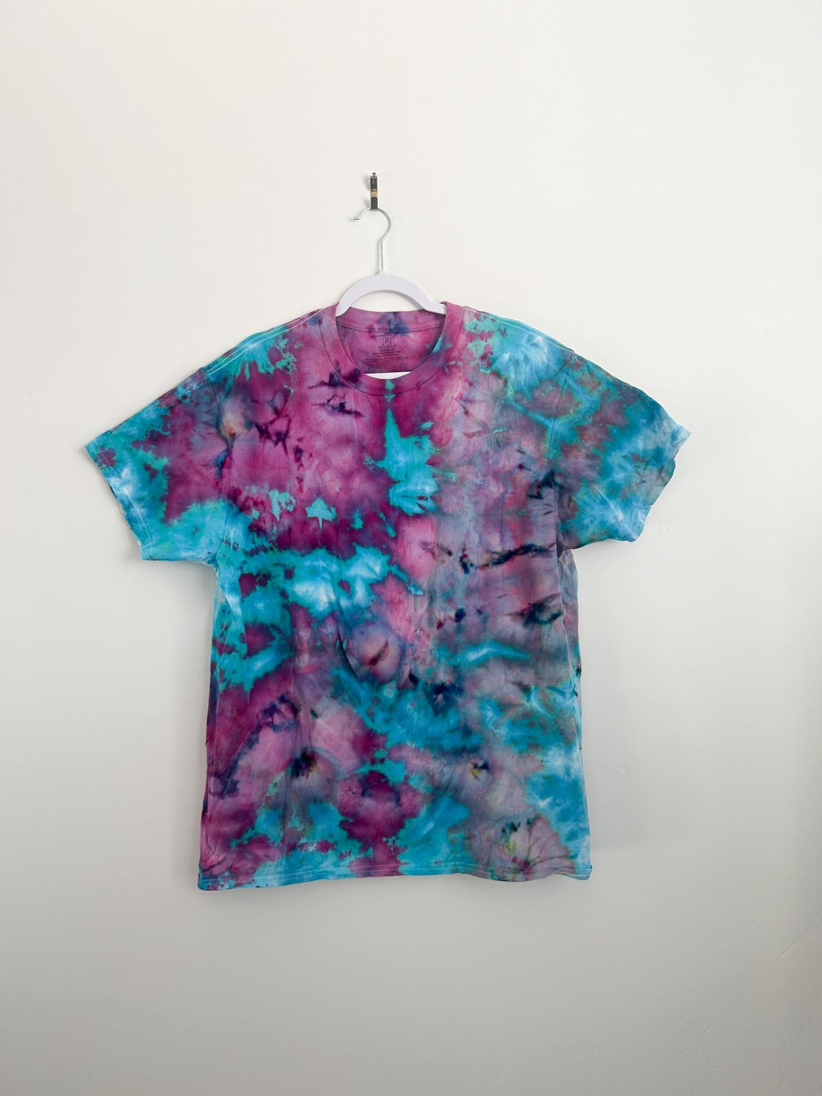 Full front view of handmade cotton candy ice dye tee in size XL on white hanger, pink magenta and teal