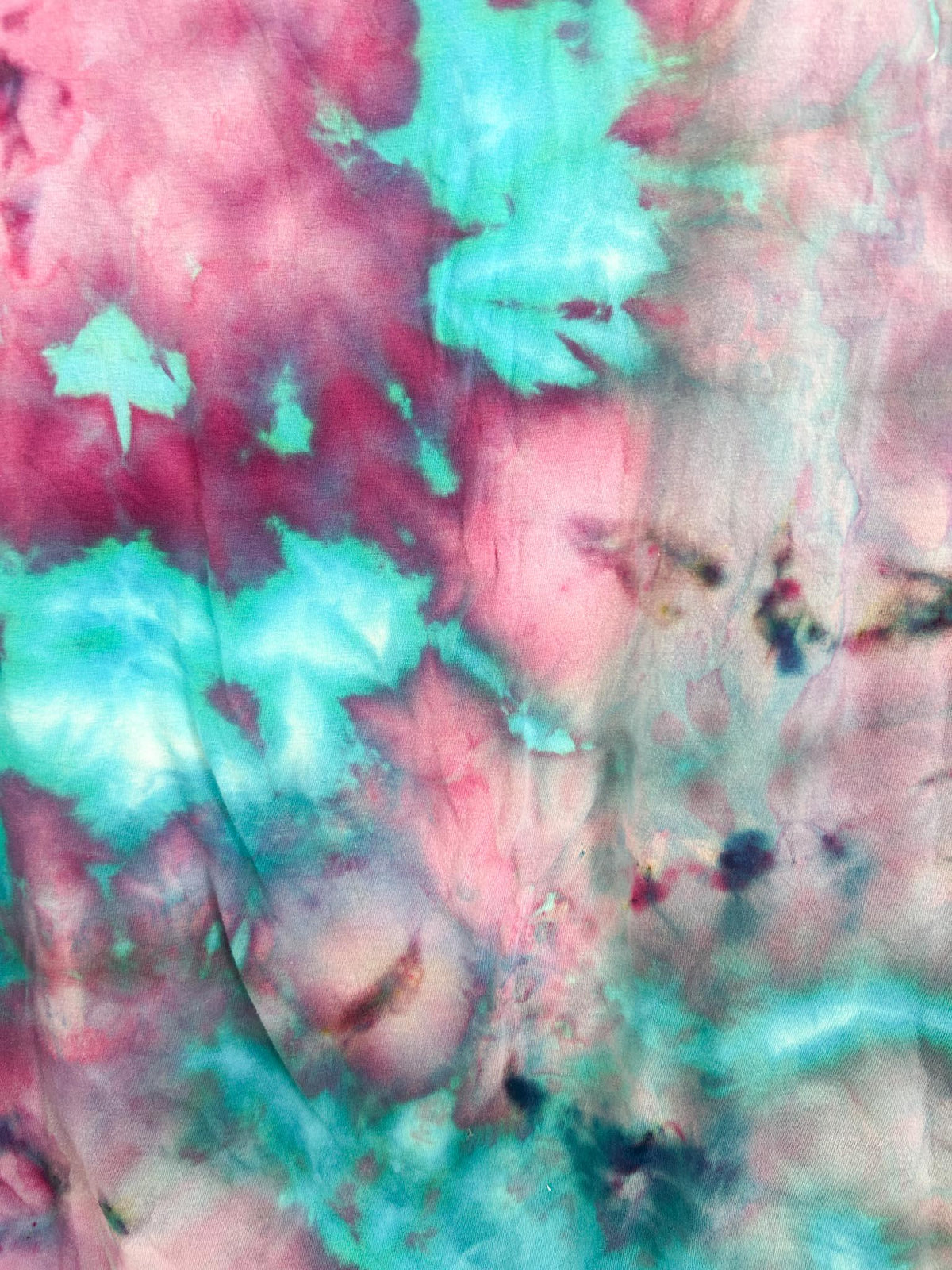 Close up of cotton candy ice dye pattern showing pink, magenta, and turquoise watercolor blooms