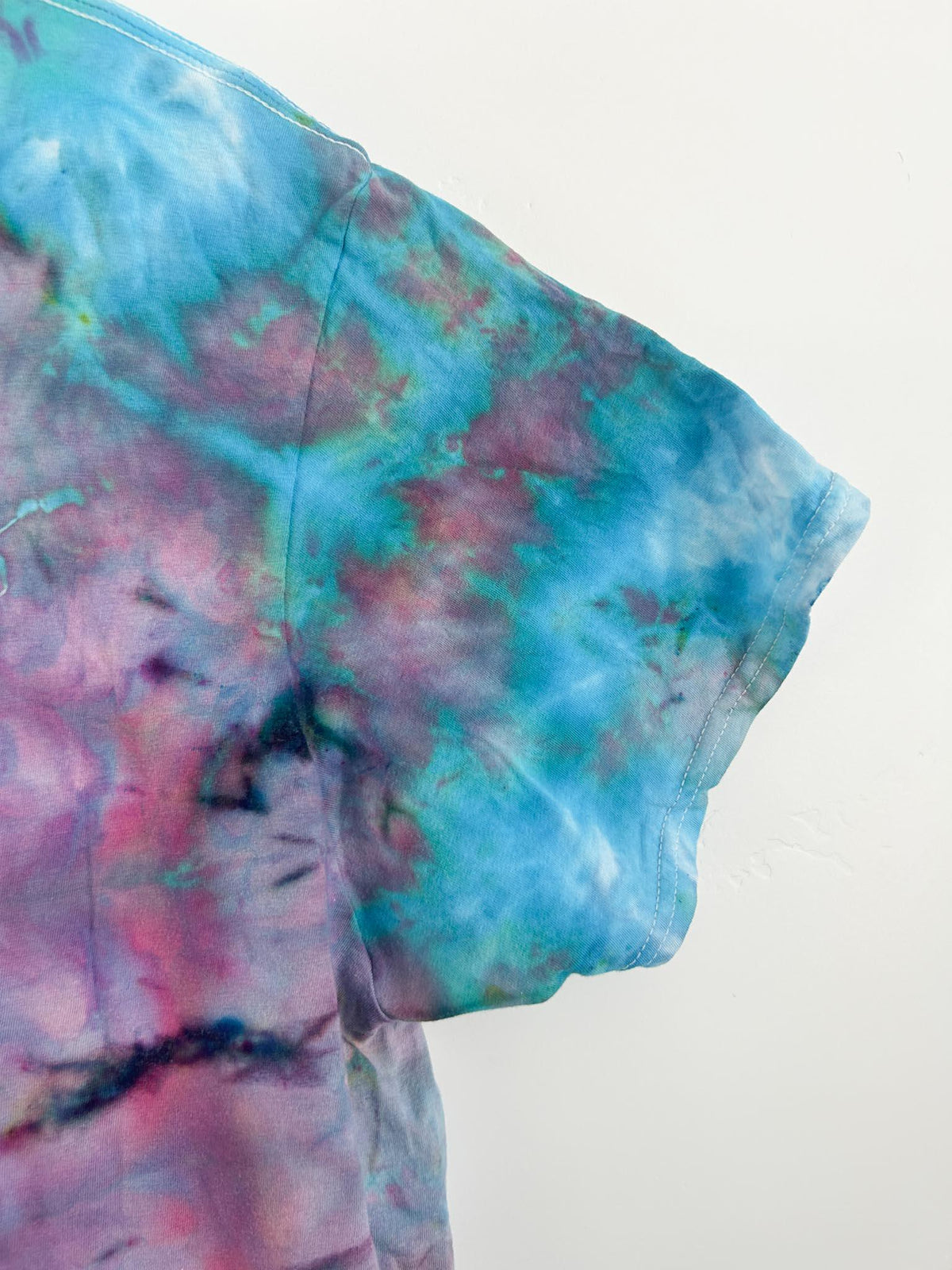Sleeve and shoulder detail of cotton candy ice dye t shirt in pink, purple, and teal