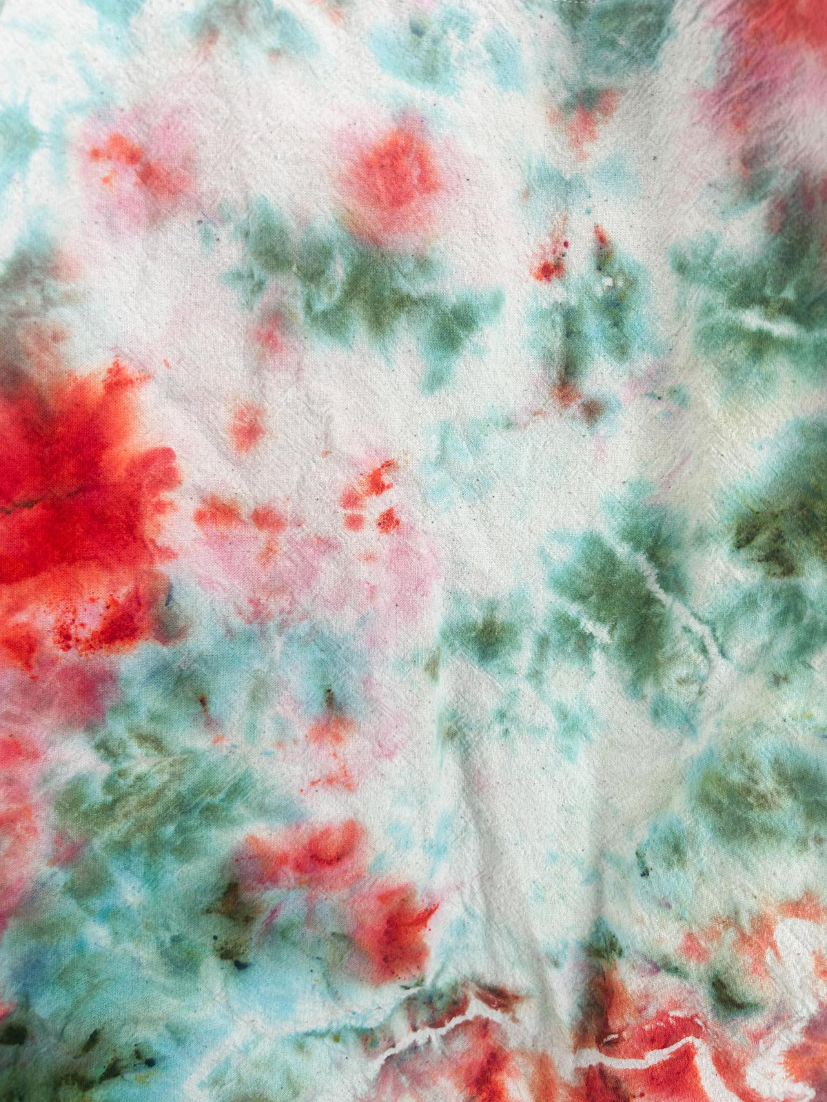 Close up of coral and teal ice dye pattern on cotton canvas tote bag with bright coral blooms and teal watercolor