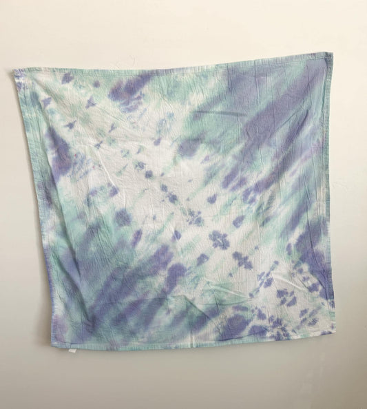 Soft mint and periwinkle pastel tie dye cotton tea towel hanging flat, with a gentle diagonal pattern on white.