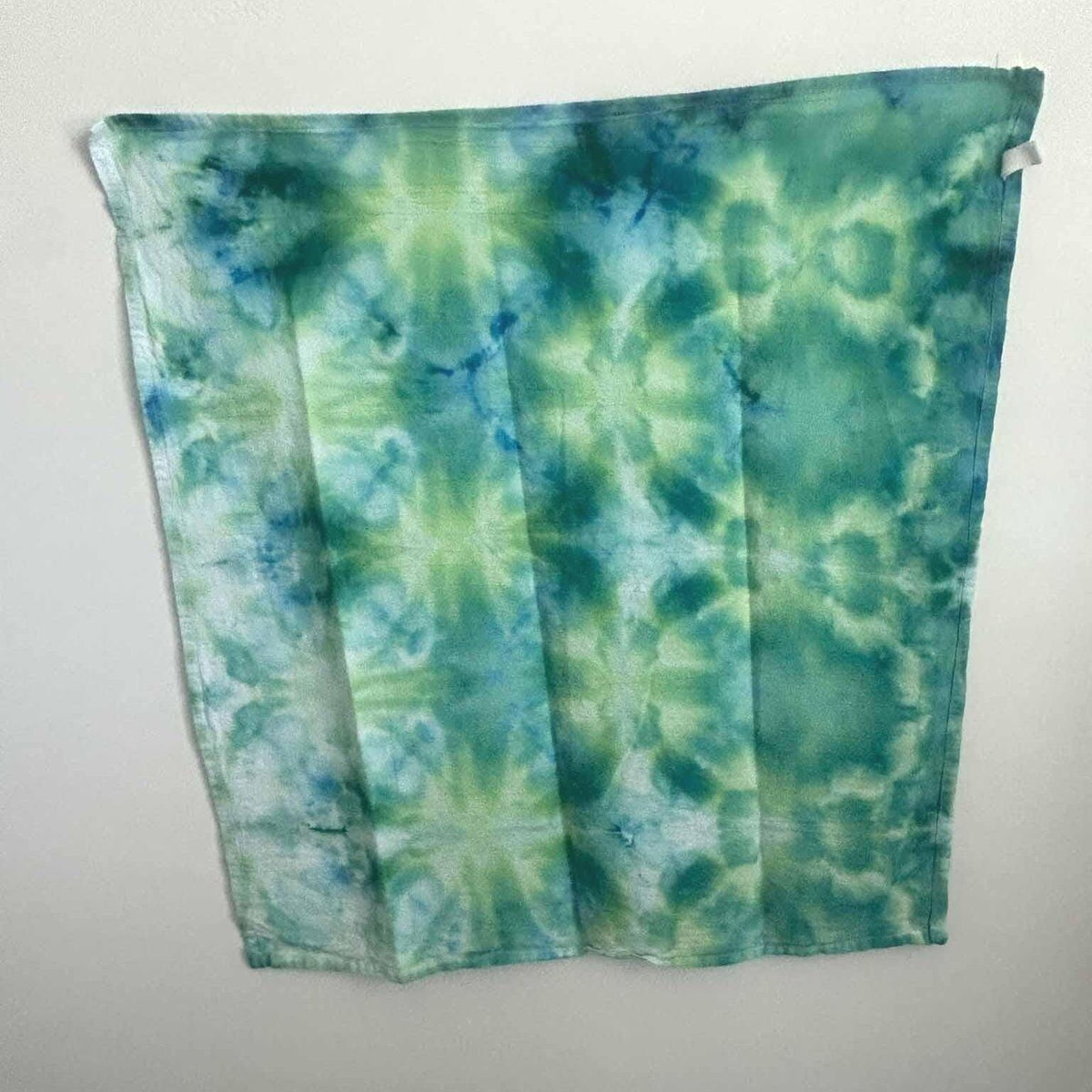 Full view of a one of a kind Rainforest ice dye tea towel in mossy green, teal, and cobalt blue.