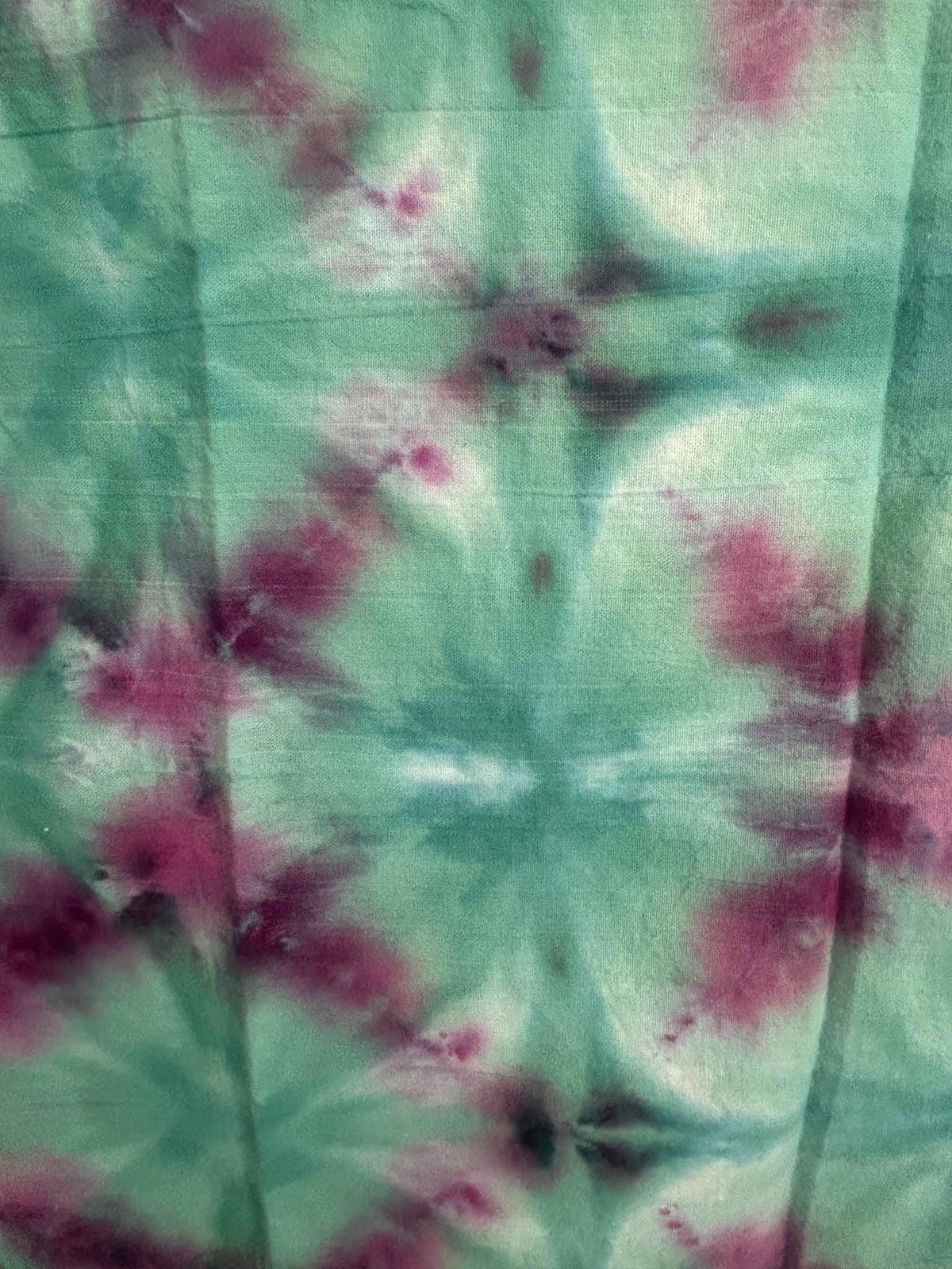 Close-up of a teal and purple ice dye towel showing the soft watercolor tie dye blooms.