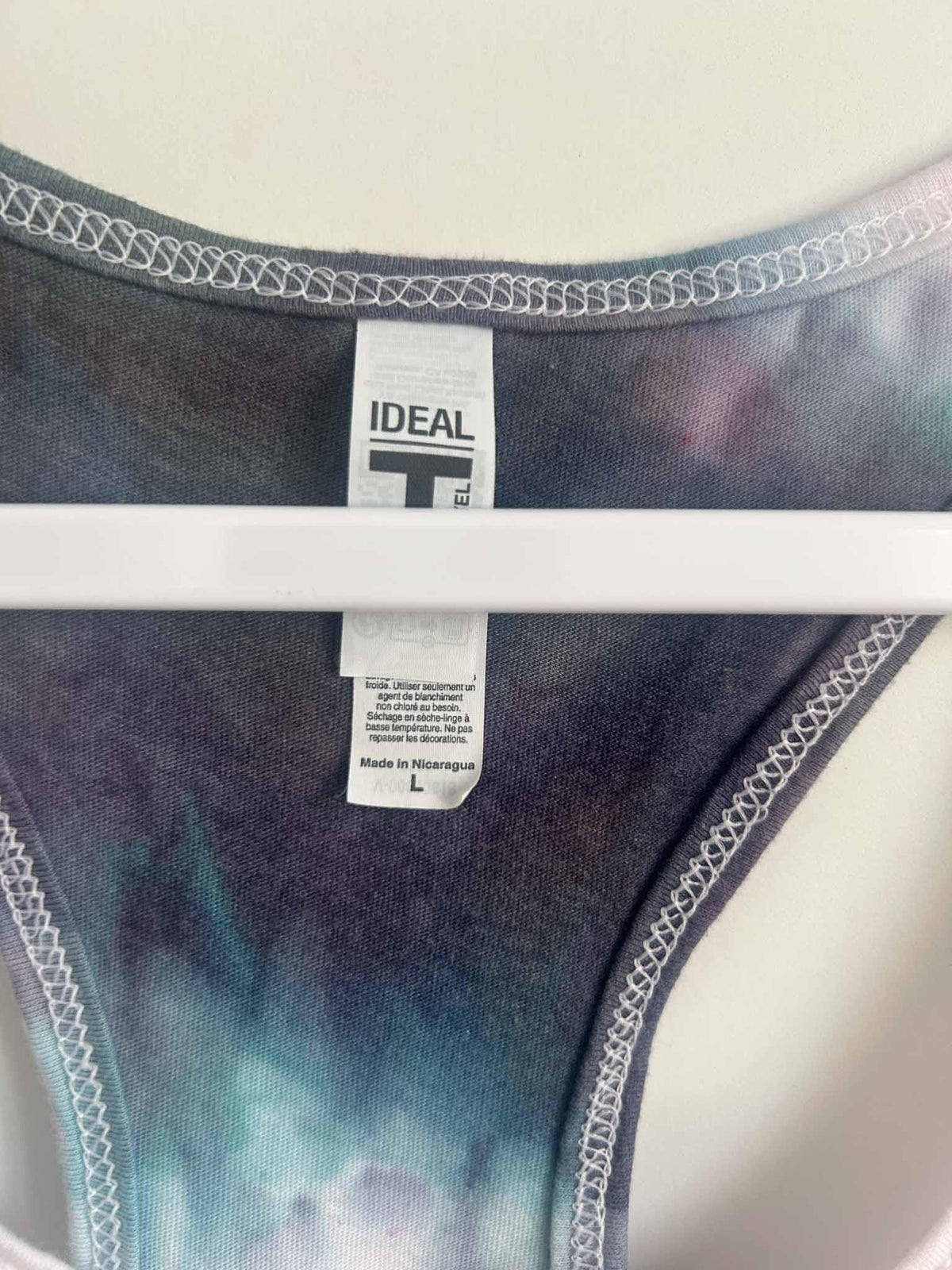 Tank top care tag showing Next Level Ideal T, size L, made in Nicaragua