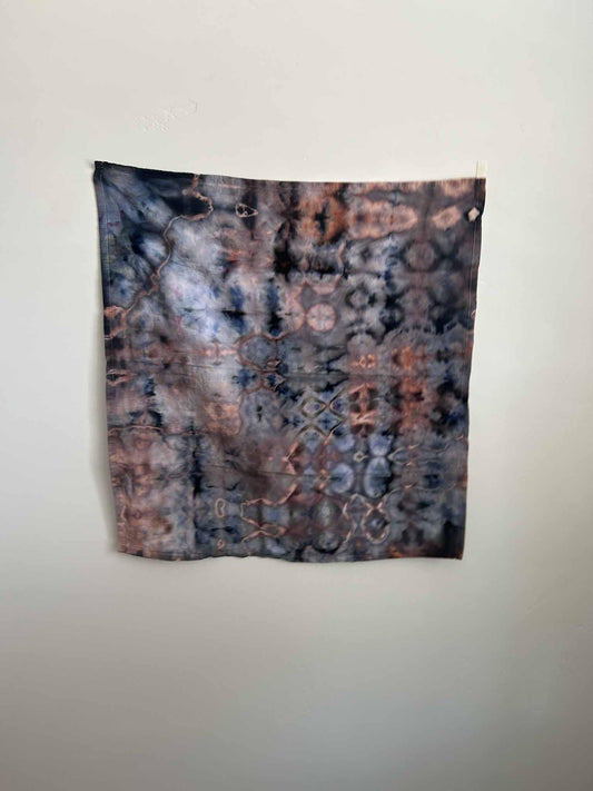 Indigo and rust ice dye tea towel with glitch geometric pattern, full view hanging