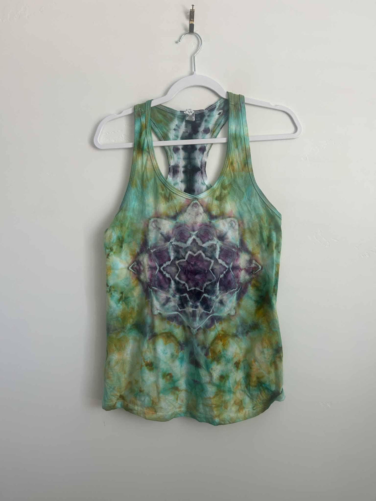 Ice dye mandala tank top in purple and green, full front view on hanger