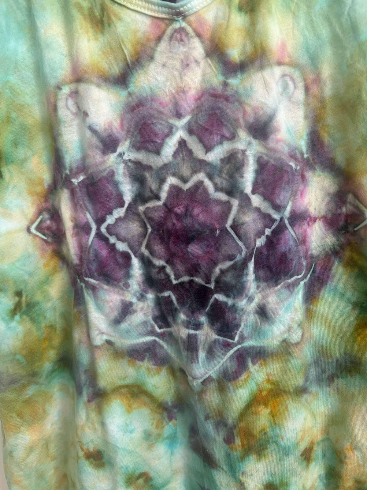 Close-up of hand dyed purple mandala design on green ice dye tank top