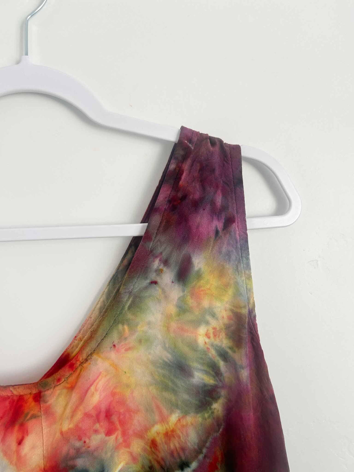 Close-up of ice dye rayon dress shoulder strap in burgundy and olive green tie dye