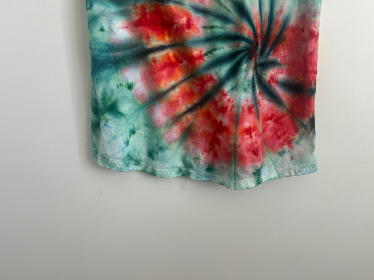 Close-up of the lower hem showing a teal and red ice dye spiral radiating in fine dark lines over green.