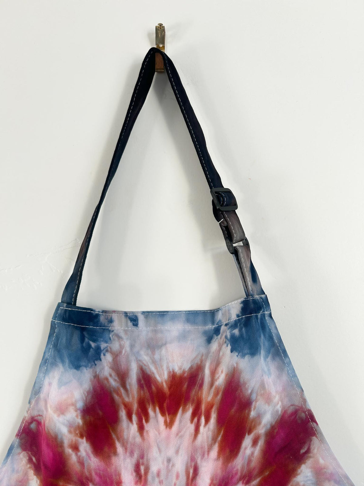 Navy and burgundy tie dye apron strap detail with adjustable buckle