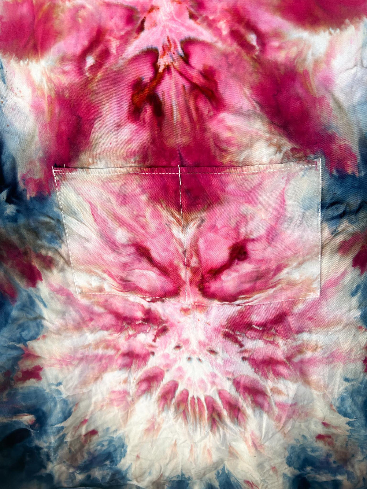 Close-up of ice dyed apron pocket showing crimson and rust mandala pattern