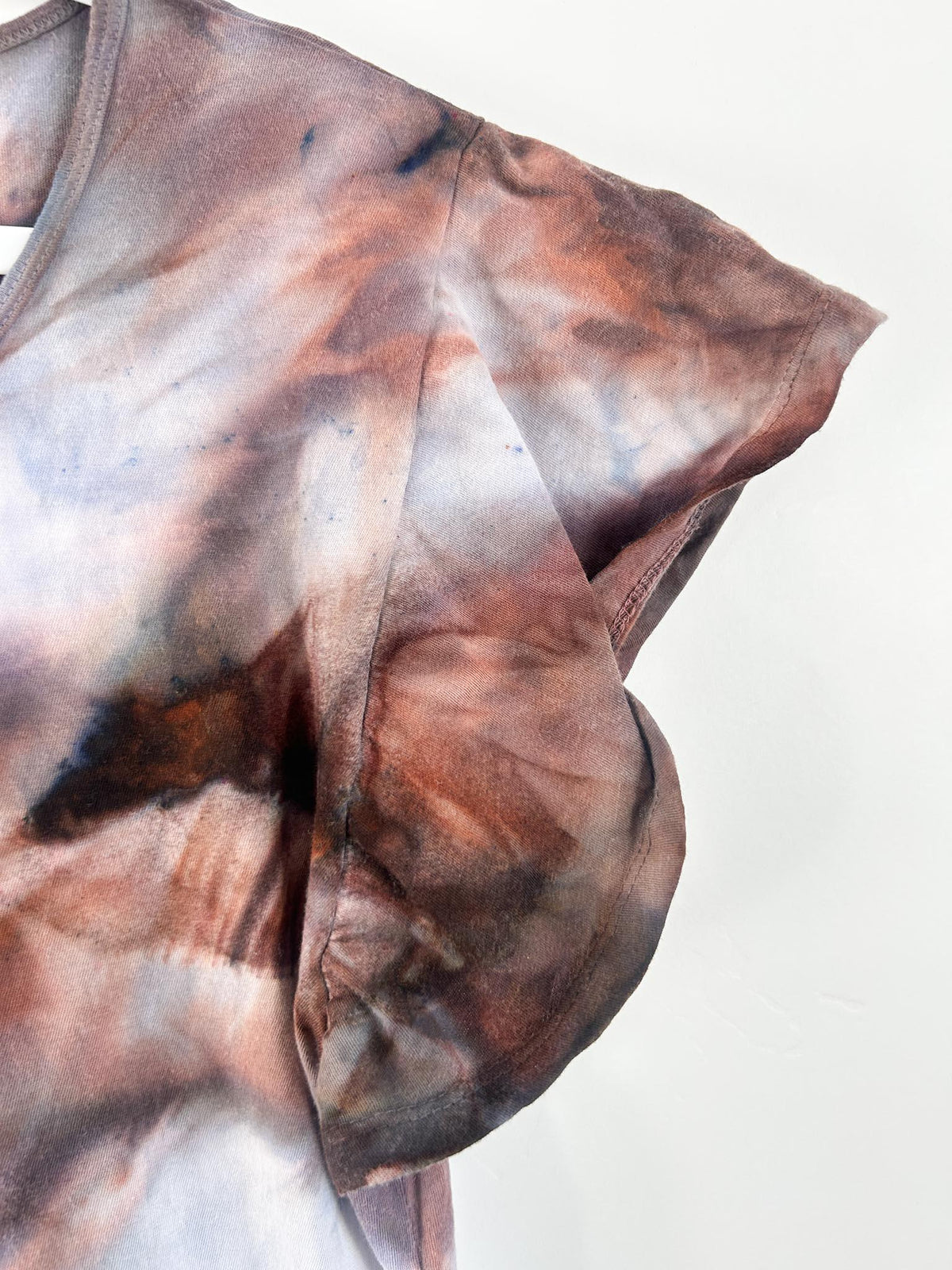 Side view of tie dye dress cap sleeve showing rust and brown ice dye detail