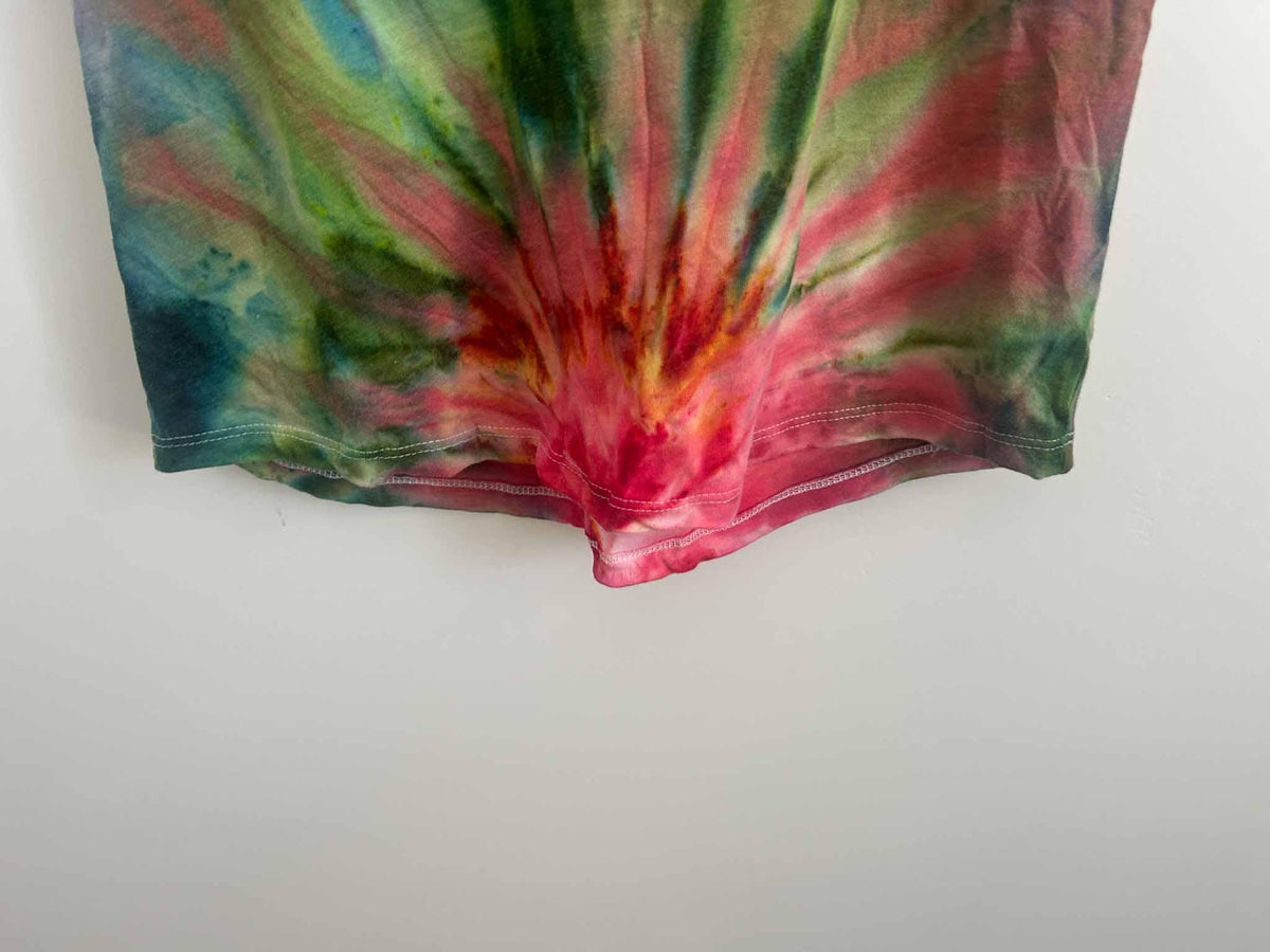Close-up of fan fold tie dye tank hem showing red, green, blue, and gold color burst
