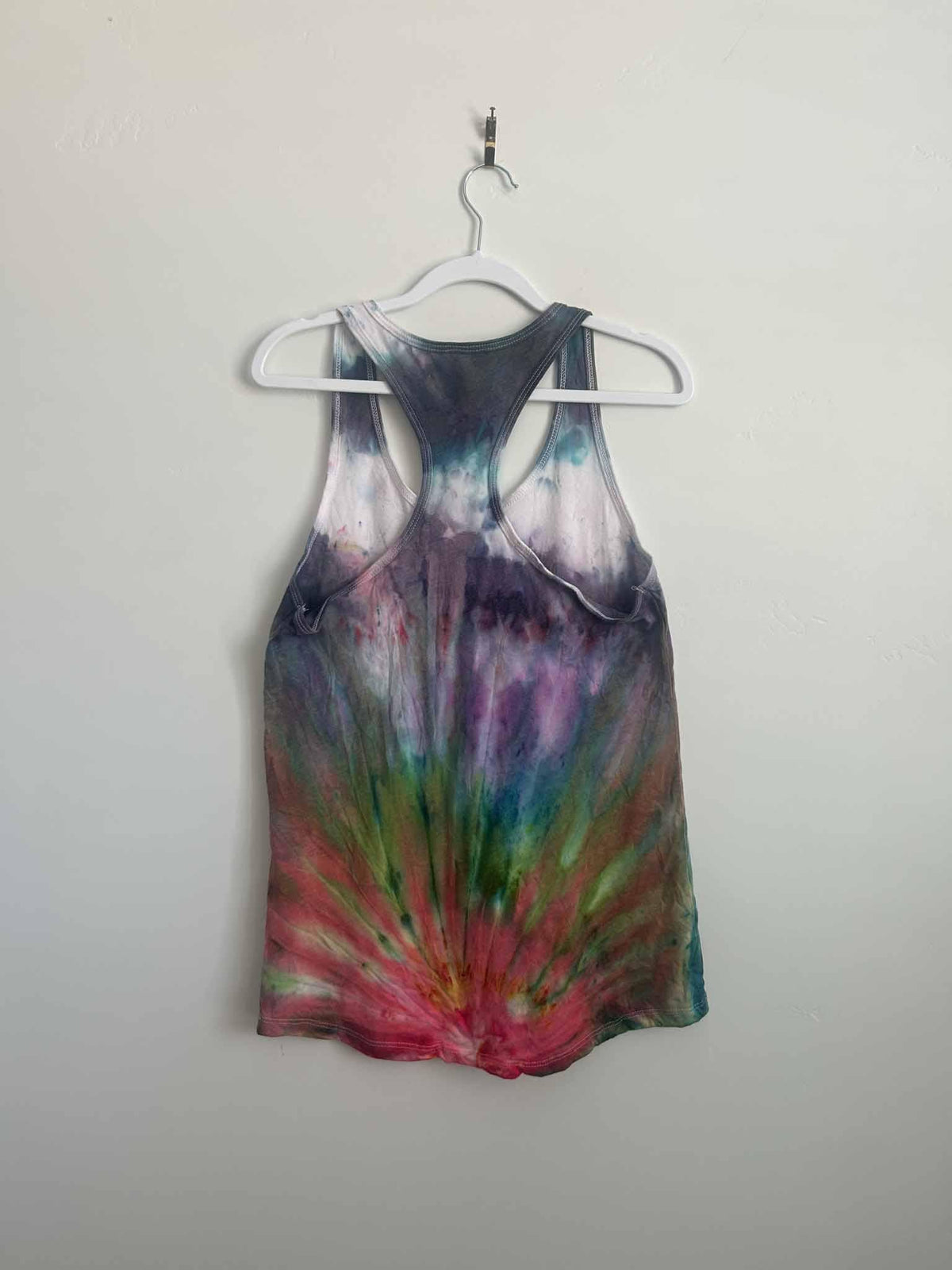 Fan fold ice dye tank top in purple ombre and rainbow burst, full back view on hanger