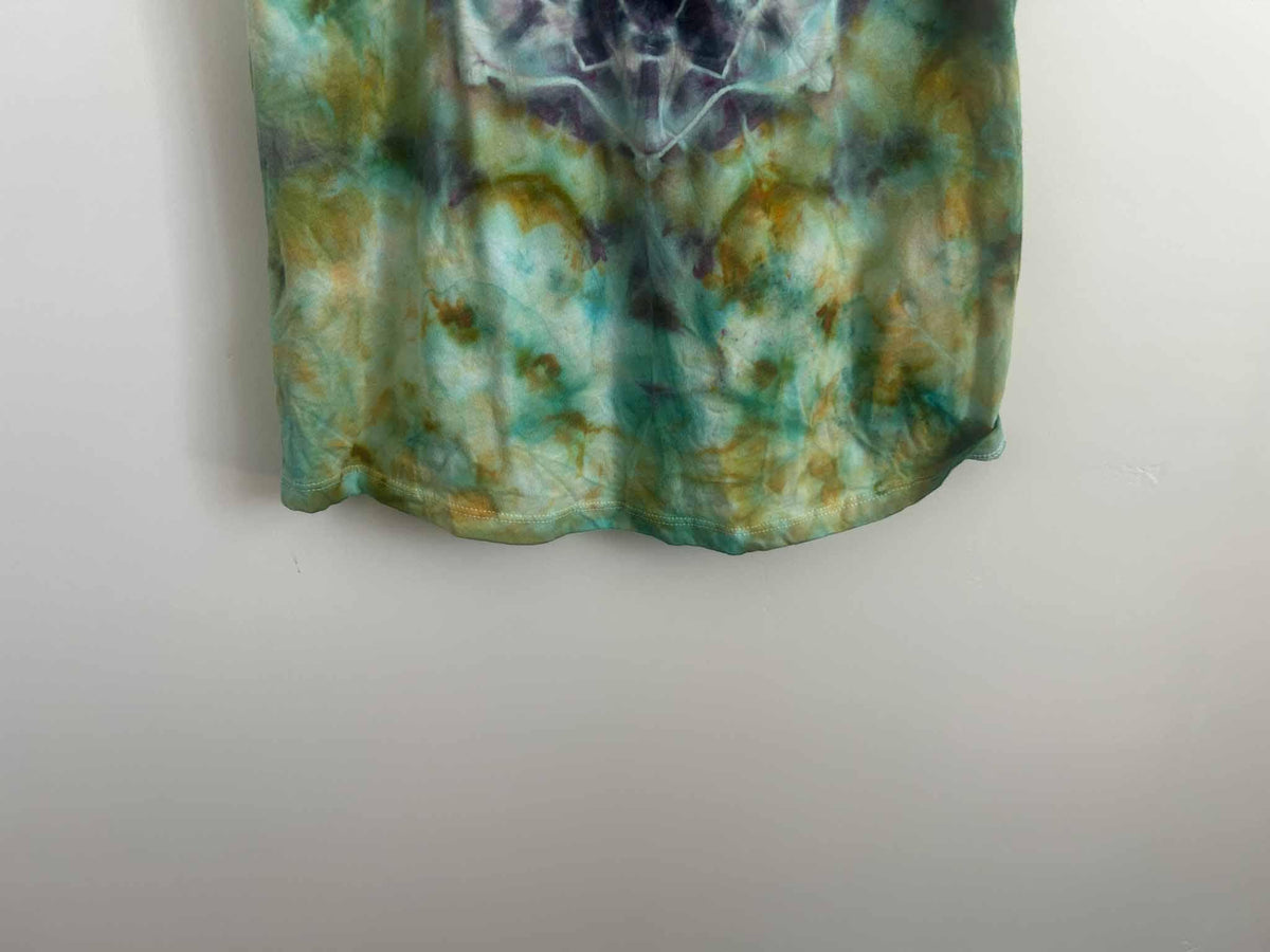 Close-up of ice dye tank top hem showing green, gold, and teal color blending