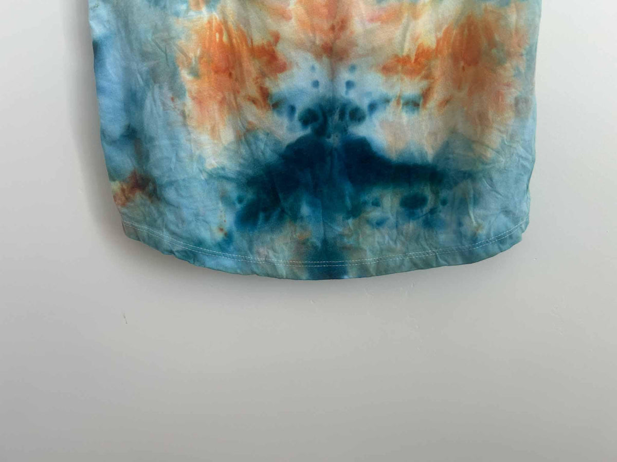 Close-up of ice dye tank top strap showing peach and rust color blending
