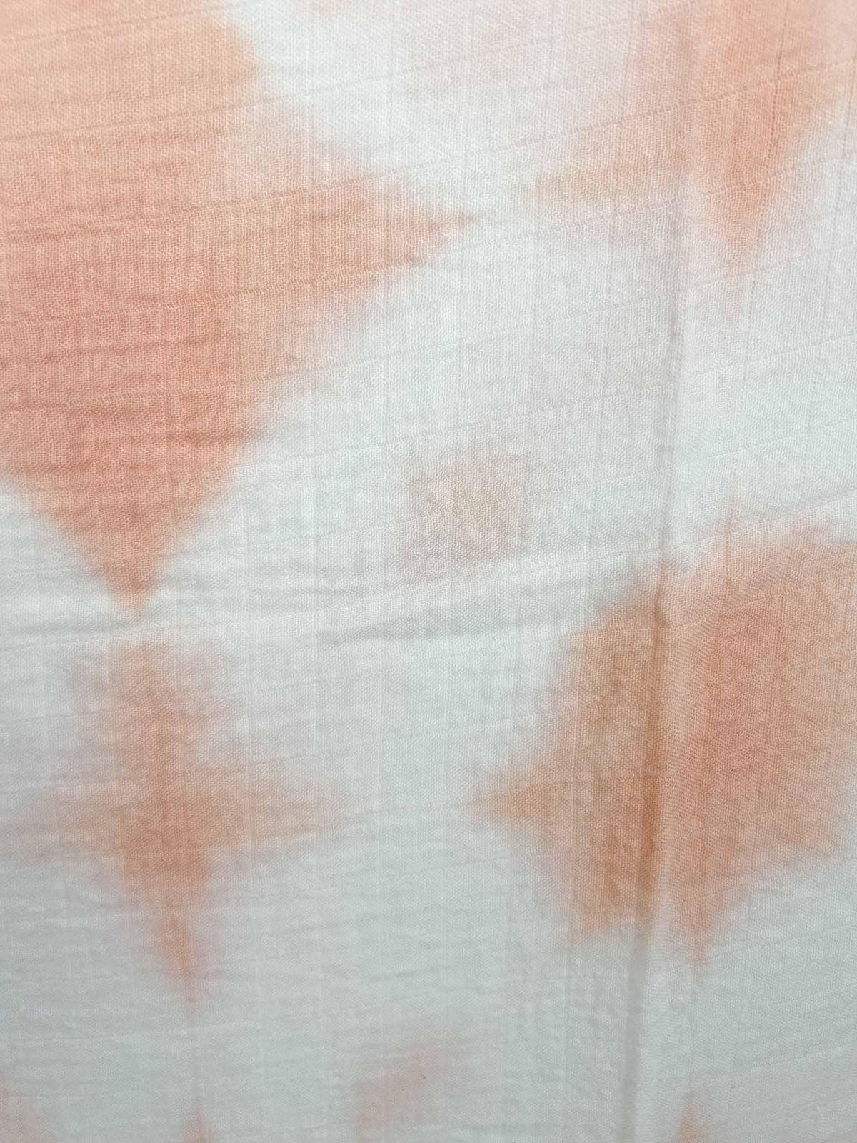 Detail shot of naturally dyed madder root peach pattern on gauze fabric showing fabric weave