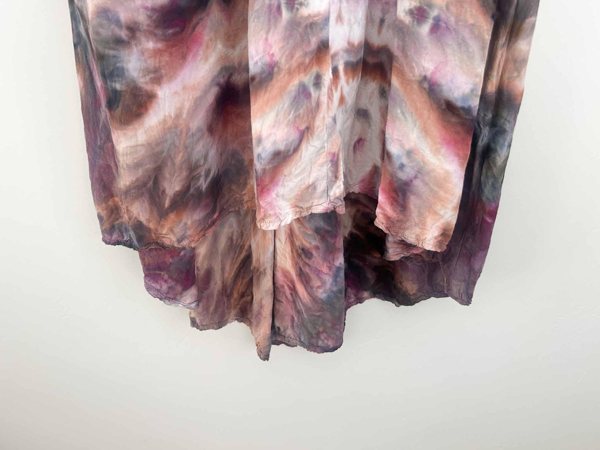 Close-up of ice dye hi-lo dress hem showing plum, rust, and mauve color blending