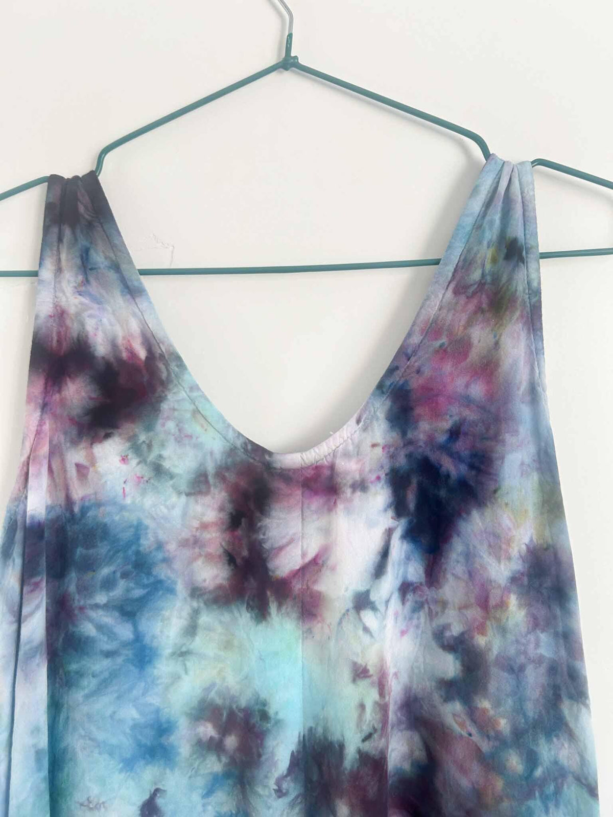 Close-up of ice dye rayon dress V-neckline showing plum, navy, and teal color blending