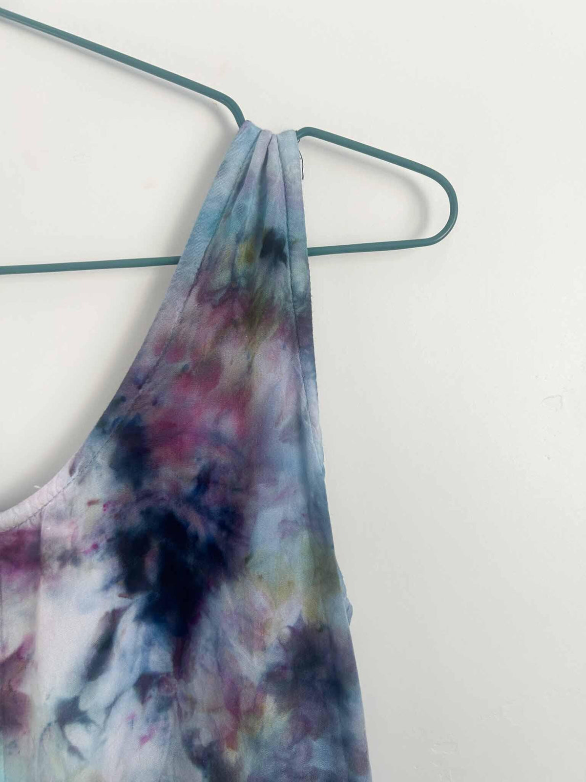 Close-up of ice dye rayon dress shoulder strap in aqua and plum tie dye