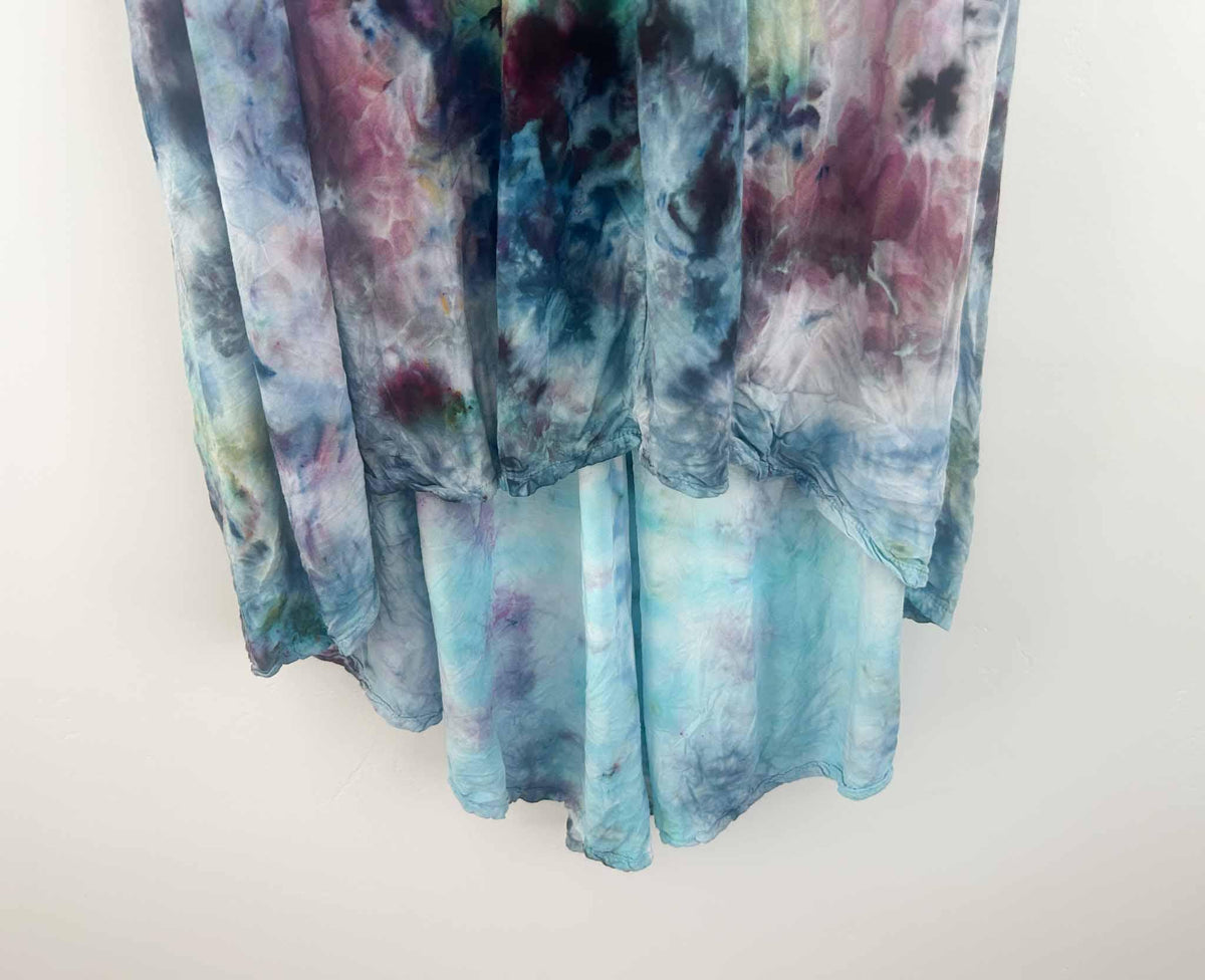 Close-up of ice dye hi-lo dress hem showing aqua underlayer and plum color blending