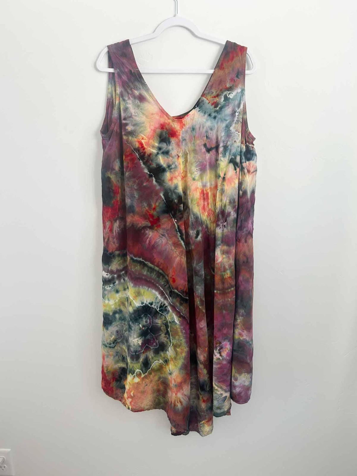 Moody geode ice dye rayon hi-lo dress in burgundy and red, full back view on hanger