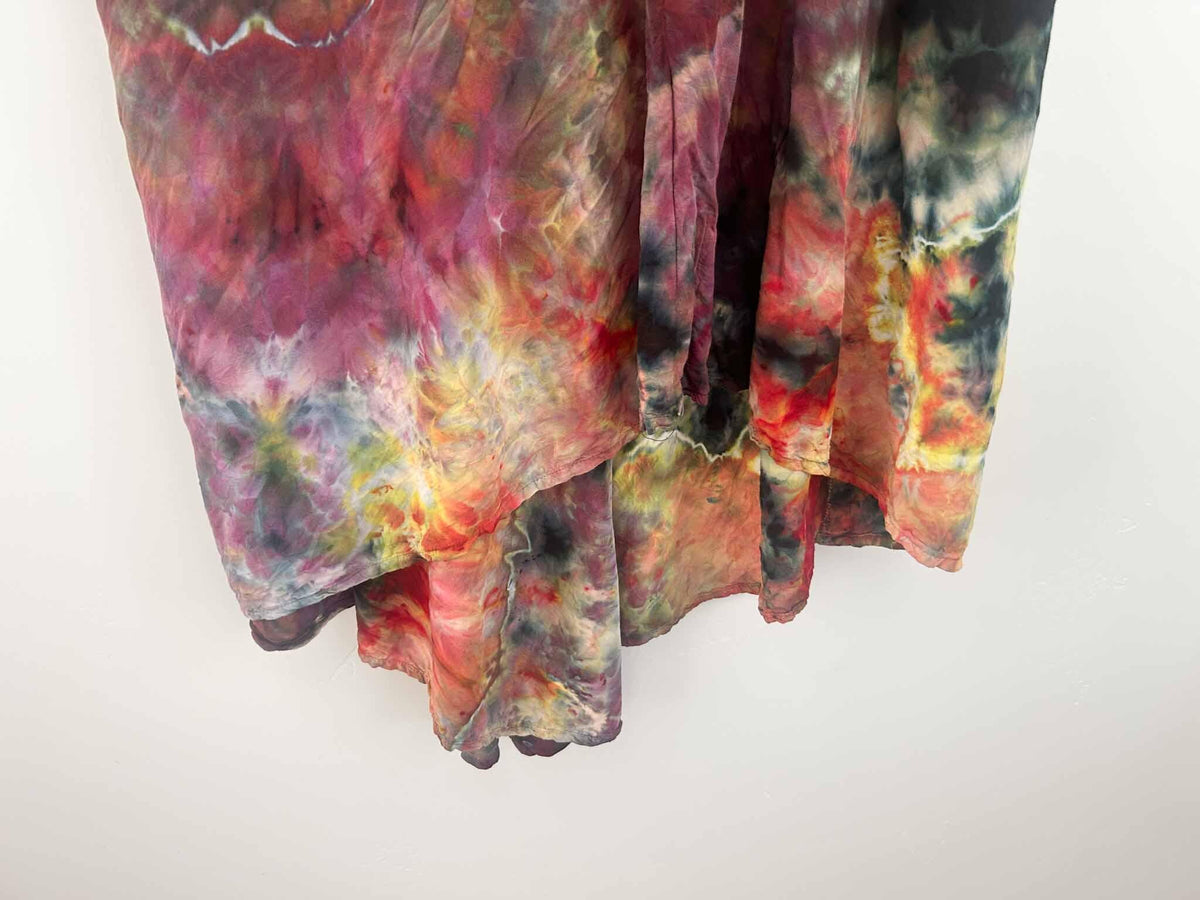 Close-up of ice dye hi-lo dress hem showing burgundy, red, and olive color blending