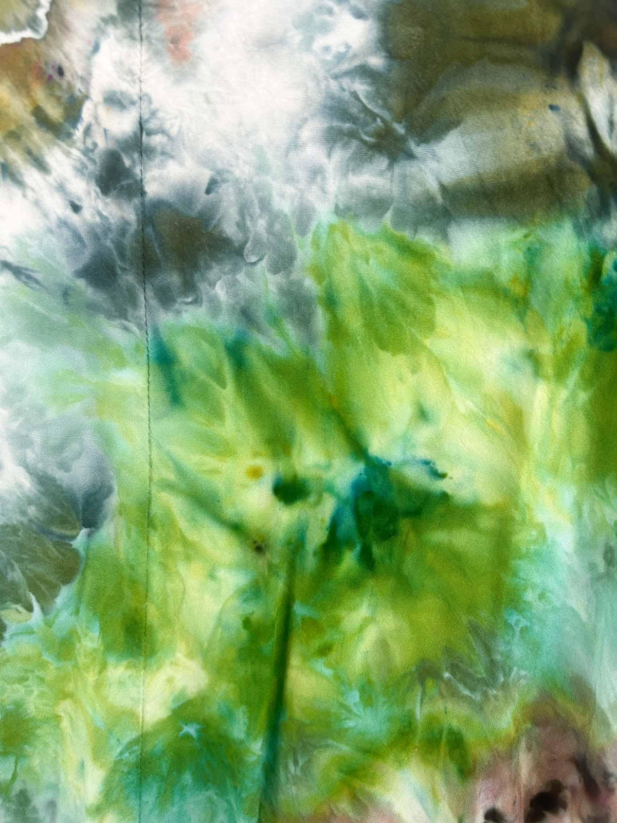 Close-up of ice dye geode dress skirt showing lime green, grey, and teal color blending