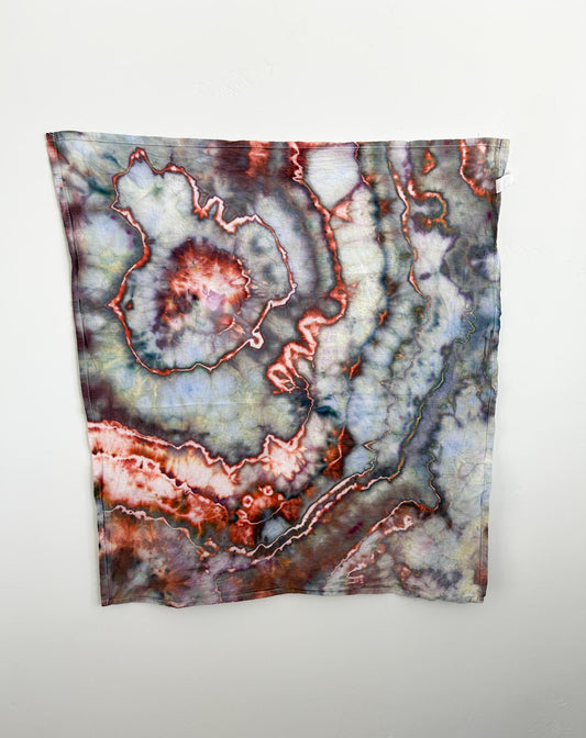 Ice dyed cotton tea towel hanging flat, full view of sage copper marbled geode pattern
