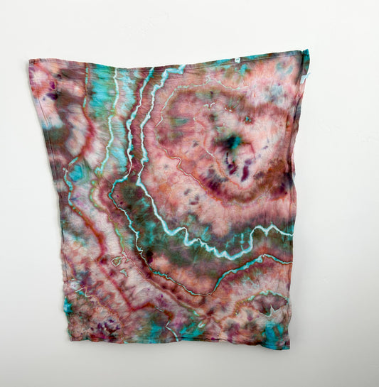 Ice dyed cotton tea towel hanging flat, full view of rose turquoise marbled pattern