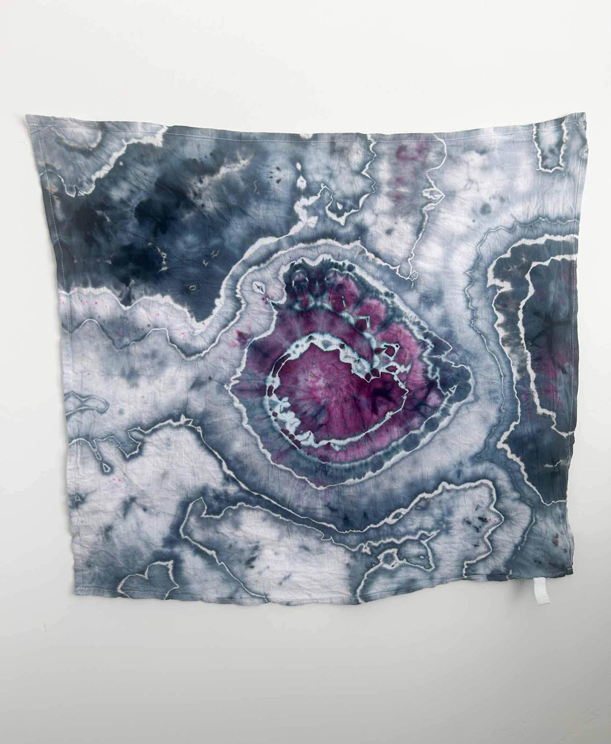 late blue and magenta geode pattern ice dyed cotton tea towel hanging flat against white wall
