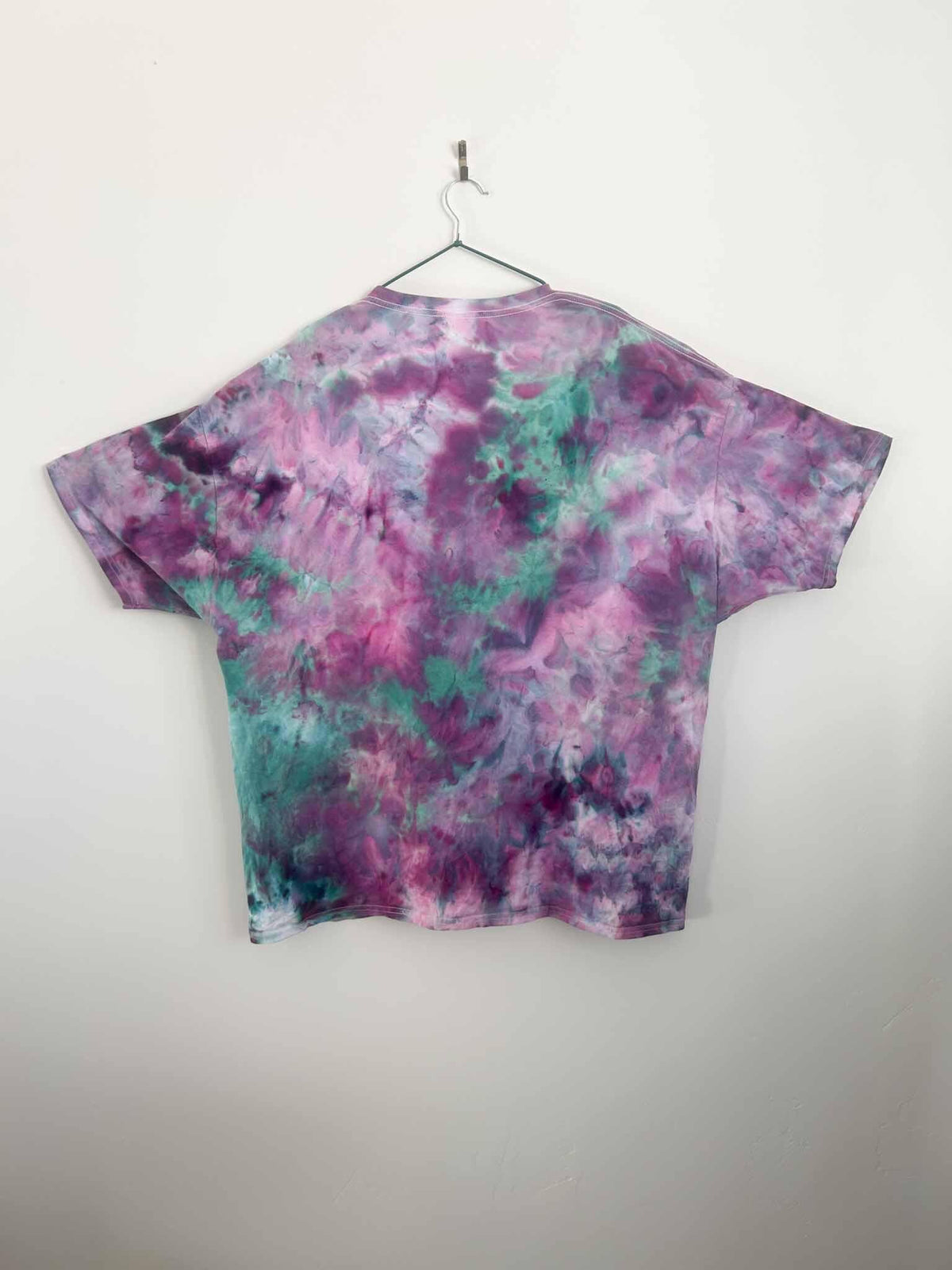 Back view of purple and teal ice dyed tie dye t-shirt on hanger