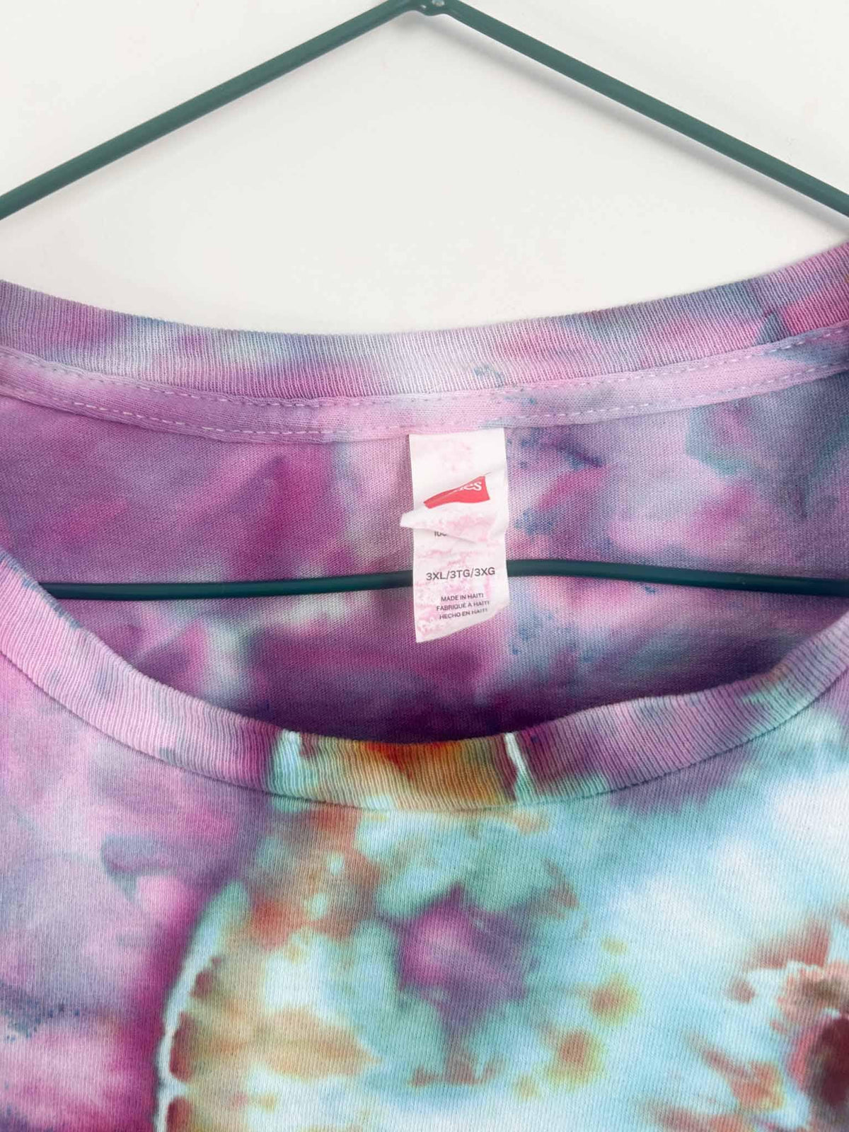 Inside collar tag showing Hanes brand and 3XL size label on tie dye shirt