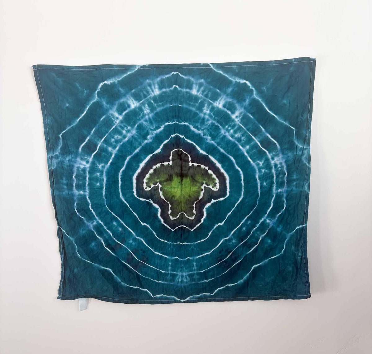 Sea turtle tie dye tea towel hanging flat, teal blue ripple background, 27x27 cotton