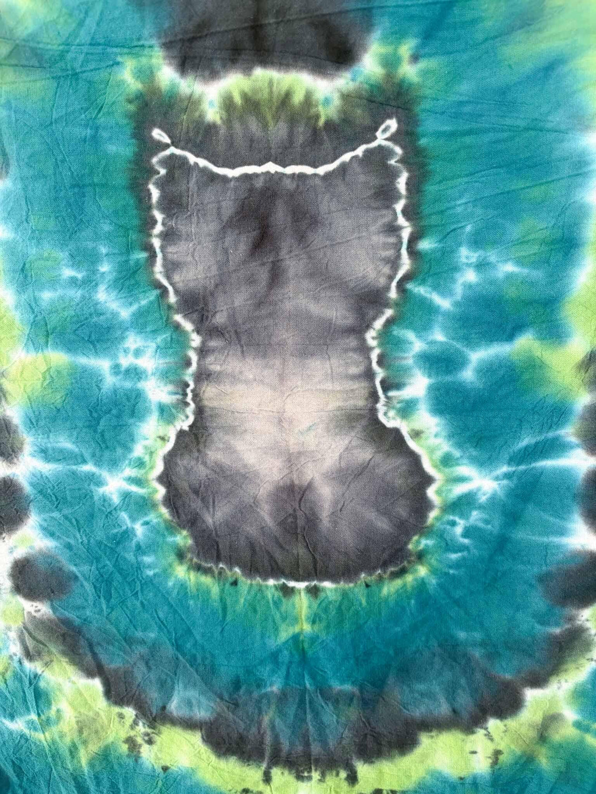 Close-up of black cat silhouette tie dye on teal and green cotton tea towel