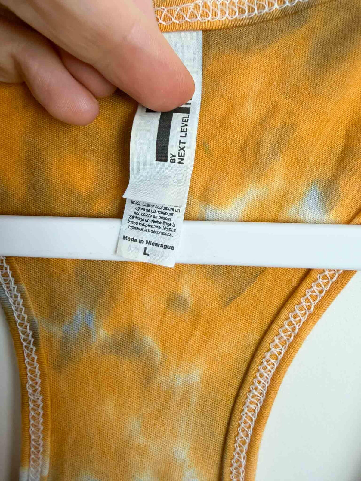 Size L tag on hand dyed tie dye racerback tank, Next Level Ideal T cotton poly blend